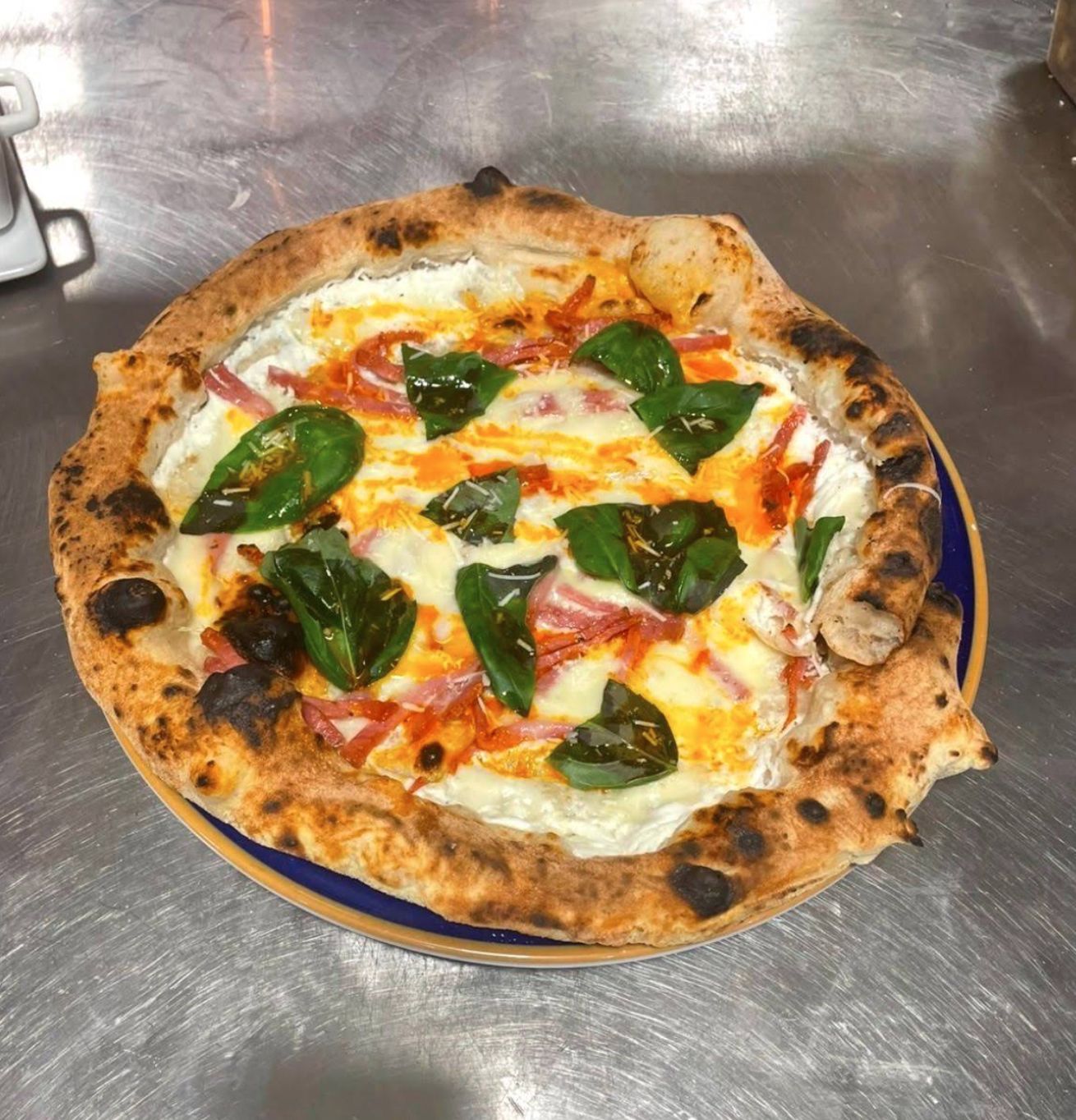 Stone baked pizza with basil and ham